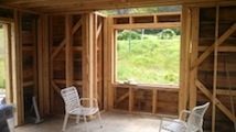 Picture of house interior under construction with board sheathing and let-in bracing